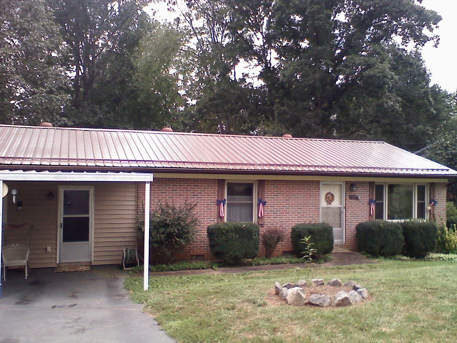 Bronze metal roof and carport on a brick ranch home — Roof Repair work by our crew in Nauvoo